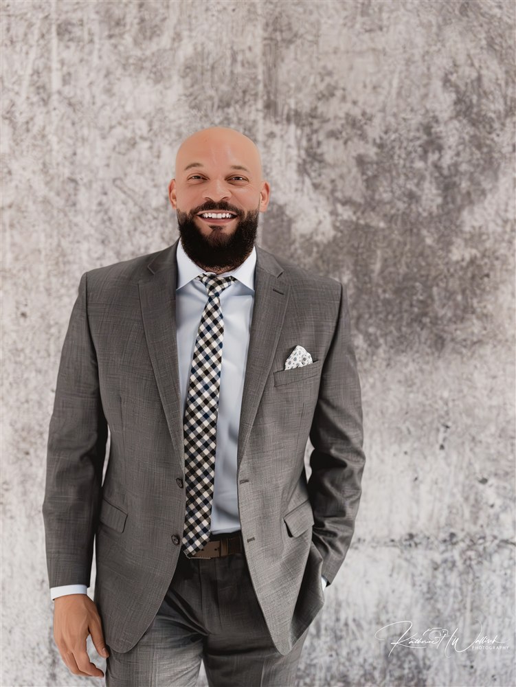 Terry McDonald smiling in a gray suit